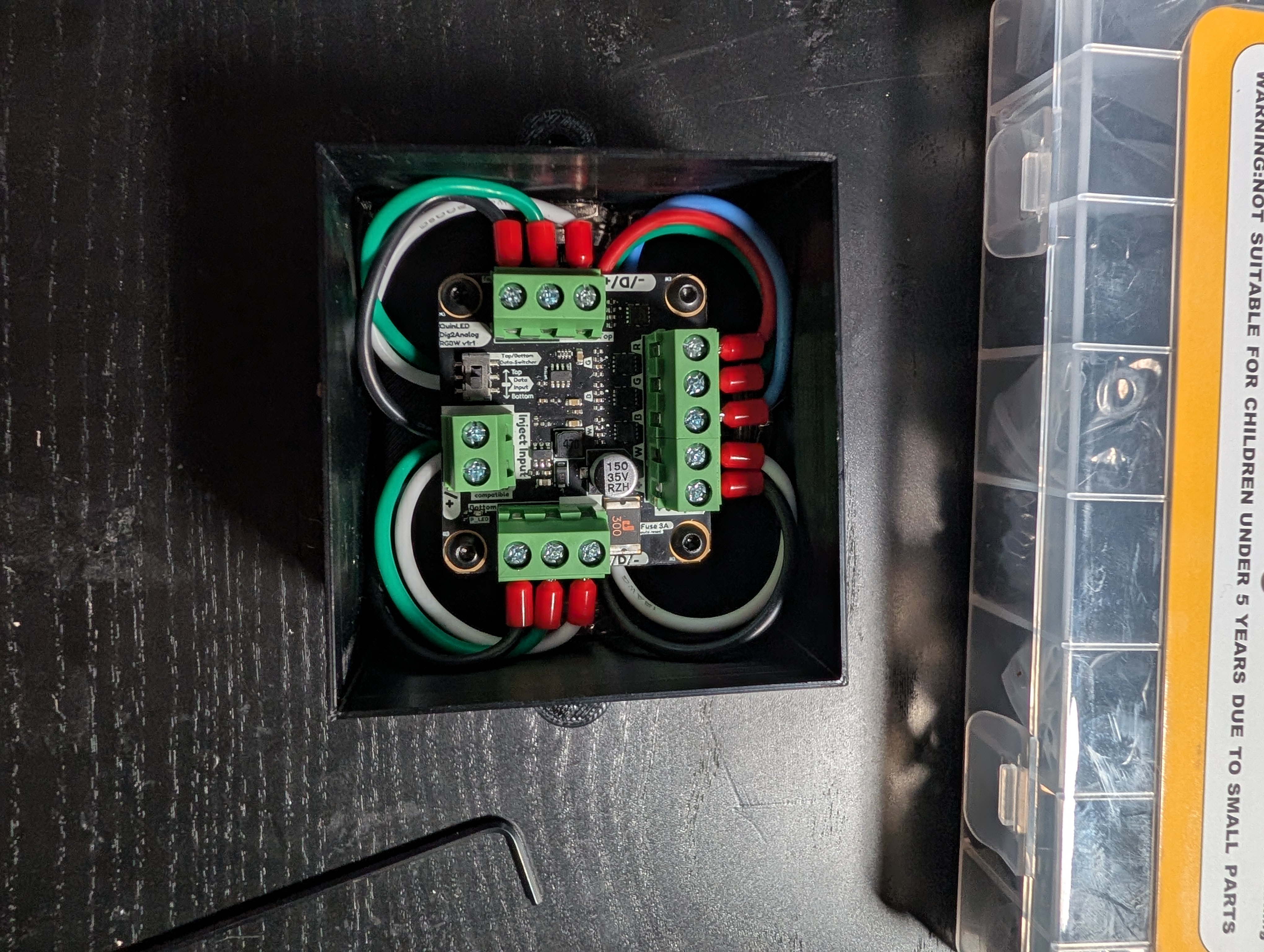 The same enclosure with a circuit board added on top and all the wires connected to terminals on the board